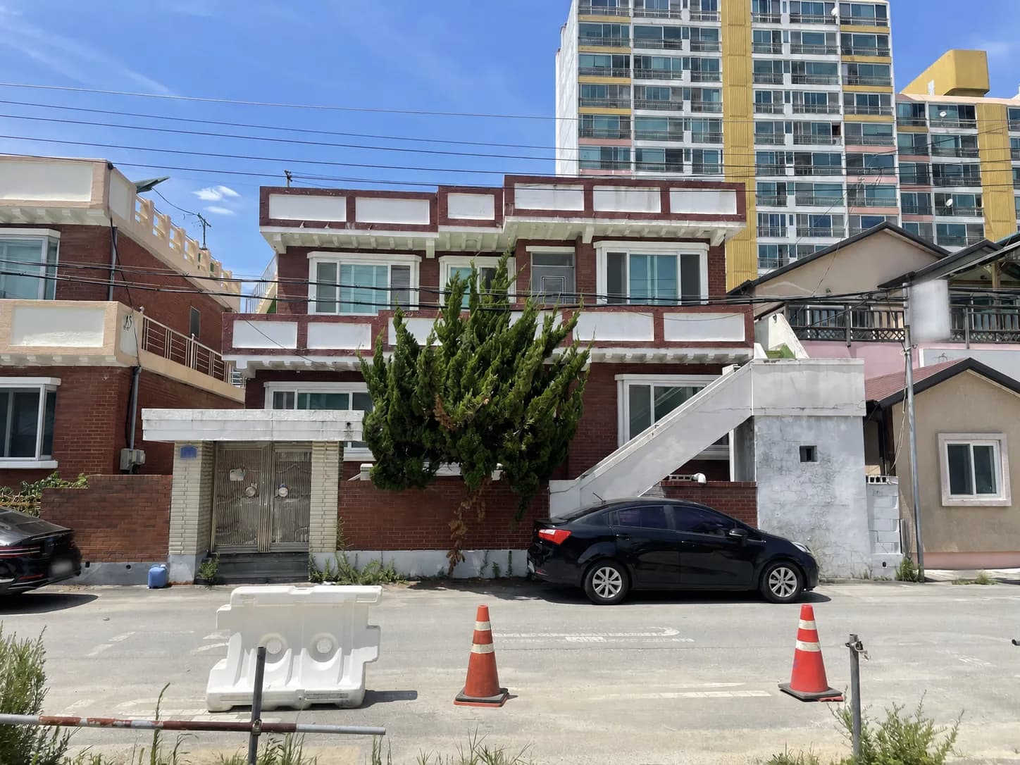 도심 주거지에 있는 붉은색과 흰색 2층 건물 정면