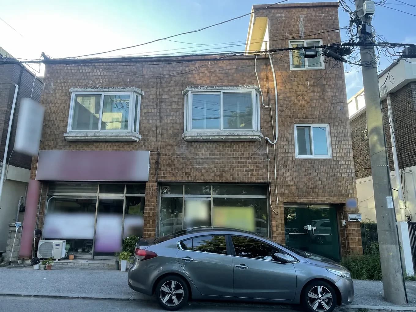 도로변에 접한 2층 갈색 벽돌 상가 외관