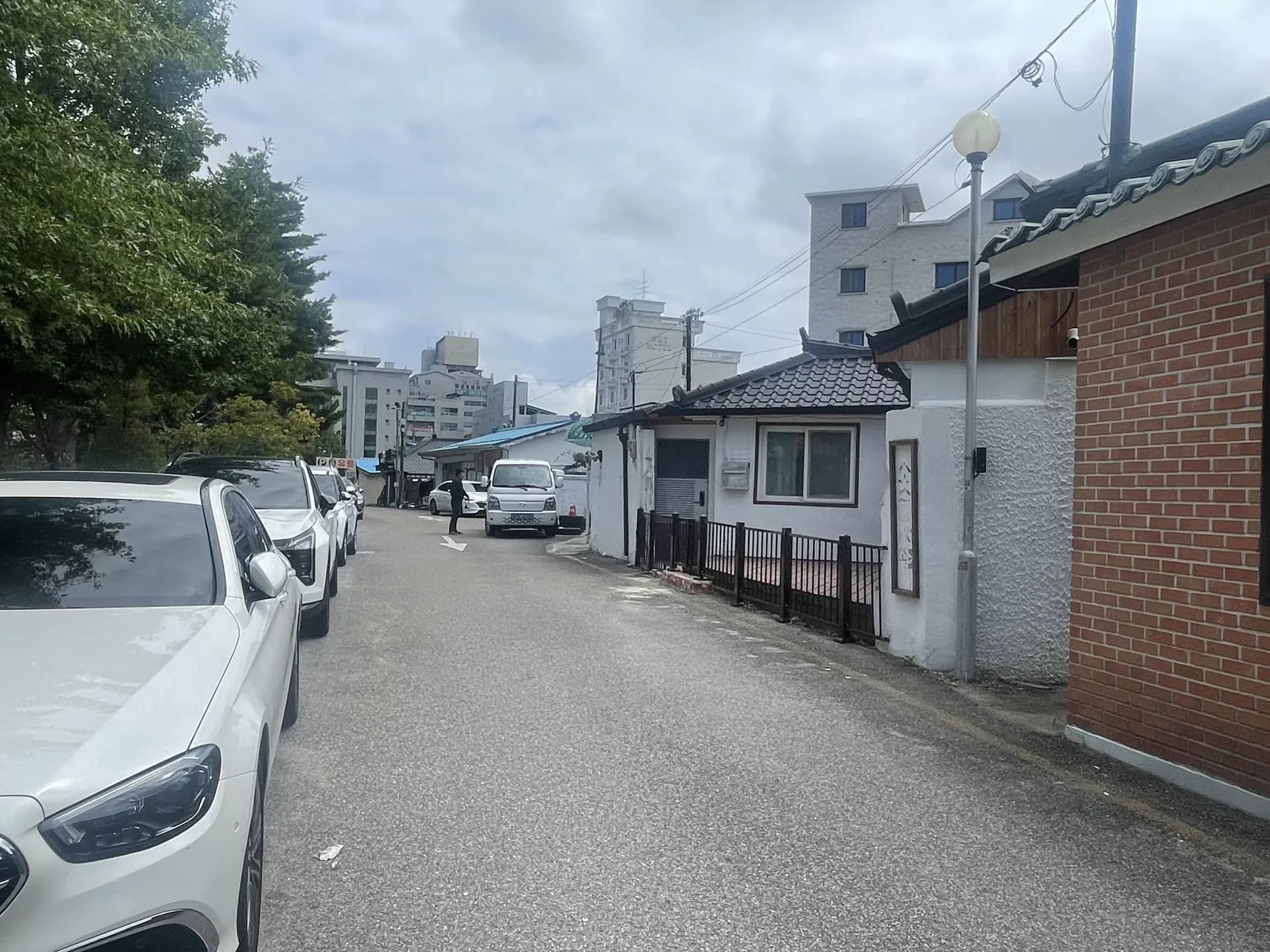 골목에서 바라본 흰색 외벽의 낮은 건물